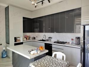 a kitchen with a white counter and a sink at Novkhanı villa in Baku