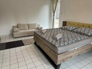 a large bed in a room with a couch at Dózsa Vendégház in Balatonboglár