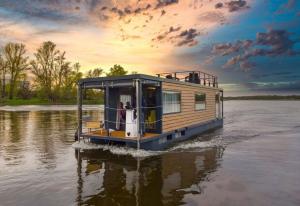 a house boat in the water on a river at Houseboat - dom na wodzie in Tarnobrzeg