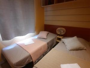 a room with two beds and a fan at Camping Domaine des iscles in La Roque-dʼAnthéron