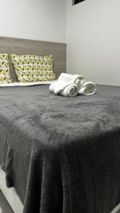 un lit avec une couverture noire dessus dans l'établissement Apartamento incrível a 1 quadra da praia, à Maceió 38 autres photos