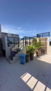 d'un balcon avec des escaliers et des plantes en pot dans un bâtiment. dans l'établissement Apartamento incrível a 1 quadra da praia, à Maceió