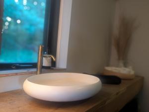 a white sink sitting on a counter in a bathroom at Nordic Designer Summerhouse - With a fantastic view in Vejby