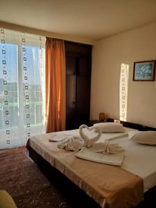 zwei Betten in einem Hotelzimmer mit Schwänen darauf in der Unterkunft Hotel National in Mamaia
