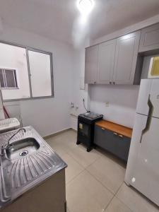 a kitchen with a sink and a stove in it at Apartamento completo em Pinda in Pindamonhangaba