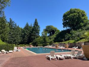 una piscina con sedie a sdraio e persone di Mobil home tout confort a Saint-Chéron