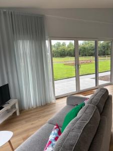 a living room with a couch and a large window at Kildare Holiday Apartments No 1 in Kildare
