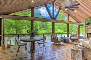 une grande véranda avec une table et des chaises dans l'établissement River Cottage of Blue Ridge - Outdoor Lounge with Gorgeous Views + a Hot Tub and Firepit!, à Blue Ridge
