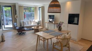 a kitchen and living room with a table and chairs at Beachfront apartment with private swimming dock in Asker