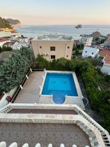 a house with a swimming pool next to the ocean at Villa VIktoria in Petrovac na Moru