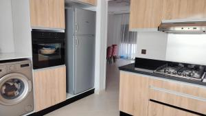 a kitchen with a refrigerator and a washing machine at Dar Amora in Ras El Ma
