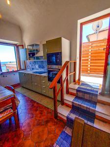 a kitchen with a staircase leading to a kitchen with a table at Appartamento La Marineria in Rio Marina