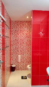 a red bathroom with a toilet and a sink at Dar Amora in Ras El Ma