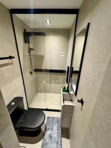 a bathroom with a toilet and a glass shower at UNU 405 Loft Luxury Corredor da Vitória: piscina + in Salvador
