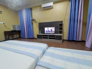 a living room with two beds and a television at Zmz Homestay in Pasir Mas