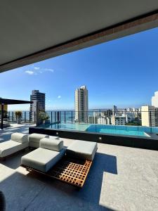 a balcony with a view of the ocean from a building at UNU 405 Loft Luxury Corredor da Vitória: piscina + in Salvador