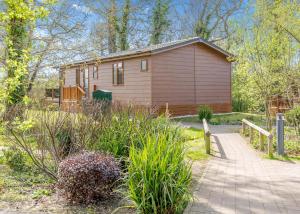 a small house in the middle of a garden at Wareham Forest Lodge Retreat in Lytchett Minster +99 photos