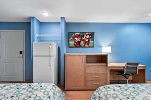 リボニアにあるHomeTowne Studios by Red Roof Detroit - Livoniaのベッドルーム(ベッド1台、デスク、冷蔵庫付) +14枚の写真