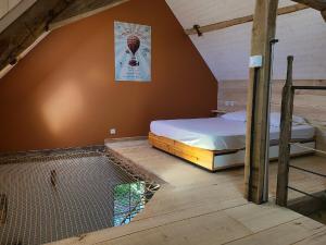 a attic room with a bed and a net at Gîte de l'Aiguille in Civray-de-Touraine