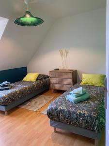 una sala de estar con dos camas y una mesa en Chambre campagne et salle de bain privée, en Le Mesnil-Guillaume