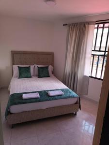 a bedroom with a bed with two towels on it at La Estrella 2 in Dosquebradas