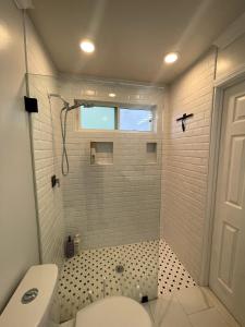 a bathroom with a shower with a toilet and a window at House in Redondo Beach 2 bedroom 1 bath in Redondo Beach