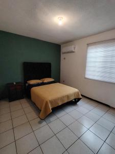 a bedroom with a bed and a green wall at Casa vacacional in Mazatlán