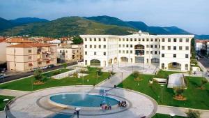 a large white building with a pool in front of it at CasaNorah in Fondi