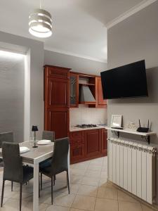 a kitchen with a table and chairs and a tv at CasaNorah in Fondi