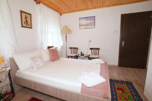 a bedroom with a large white bed in a room at Guest House Denis in Gjirokastër
