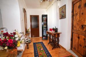a room with a hallway with a table and flowers at Guest House Denis in Gjirokastër