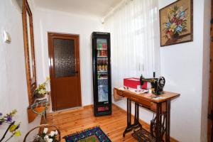 a room with a table and a soda machine at Guest House Denis in Gjirokastër