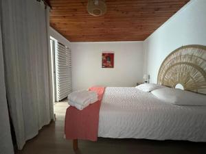 a bedroom with a large bed with a wooden ceiling at Kaz a Nyla - Face à la plage de Terre Sainte in Saint-Pierre