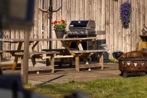 a picnic table with a grill next to a fence at Bed&Bbq Longhornranch in Akersloot +30 photos