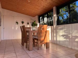 a dining room with a table and chairs on a porch at Kaz a Nyla - Face à la plage de Terre Sainte in Saint-Pierre