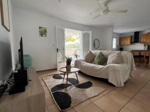 a living room with a white couch and a table at Kaz a Nyla - Face à la plage de Terre Sainte in Saint-Pierre