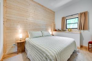a bedroom with a bed and a wooden wall at Lake and Boat Launch Access Modern Monticello Home in Monticello