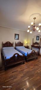 a bedroom with two beds and a chandelier at Pamplona Zizur in Zizur Mayor