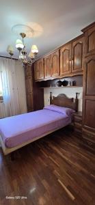 a large bed in a room with wooden cabinets at Pamplona Zizur in Zizur Mayor