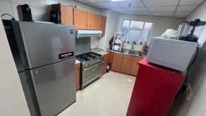 a kitchen with a stainless steel refrigerator and a stove at AlNahda Border SHJ-DXB -ZAMAZM GuestHouse in Sharjah