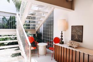 a living room with a staircase and red chairs at Cherry Warehouse Hotel in Kansas City