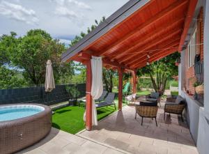 a patio with a hot tub and a pergola at House Madrino in Kreševo
