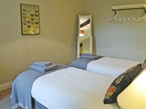 a room with two beds and a mirror at Havannah Cottage in Alnham