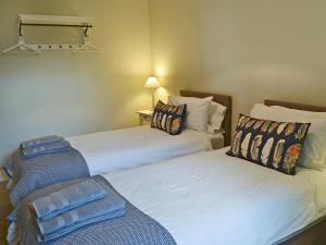 two beds sitting next to each other in a room at Havannah Cottage in Alnham