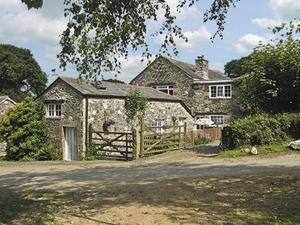 a large stone house with a wooden gate in front of it at Dove Cottage in South Hill