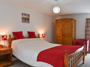 a bedroom with a large bed and a red chair at Dove Cottage in South Hill