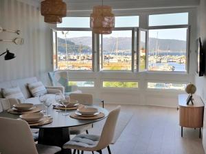 a living room with a table and chairs and a large window at Muros sobre el puerto in Muros