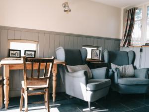 Zimmer mit Stühlen, einem Tisch, einem Tisch und einem Stuhl in der Unterkunft Southfield Cottage in Braunston
