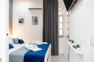 a bedroom with a bed with blue and white sheets at Scugnizzo Apartment SMART in Naples