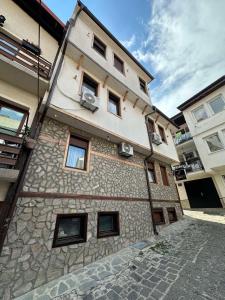 a large stone building with windows on a street at Villa Harmony in Ohrid